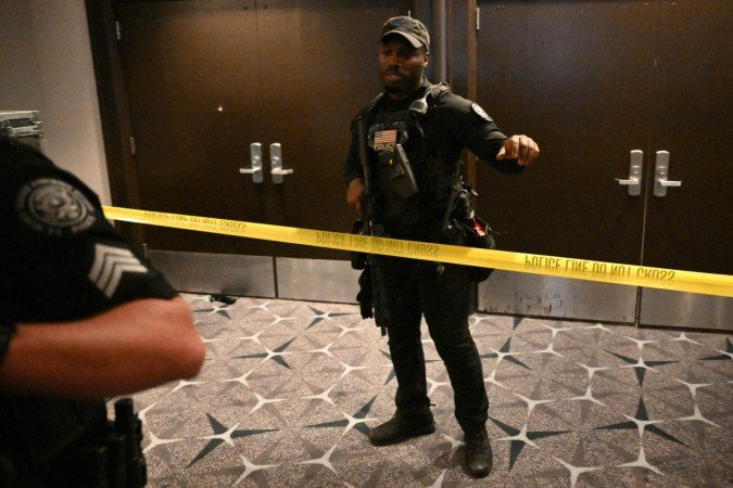  An armed police officer gestures behind police tape after shots were reportedly fired during the White House Correspondents' dinner at the Washington Hilton in Washington, DC, on April 25, 2026. Shots were allegedly fired as US President Donald Trump attended a press dinner in Washington on Saturday night, witnesses and AFP reporters said as loud bangs were heard at the hotel venue. (Photo by Mandel NGAN / AFP)
      Caption 