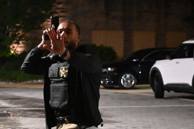  A Secret Service officer directs people outside the Washington Hilton after shots were heard during the White House Correspondents' Dinner in Washington, DC, on April 25, 2026. President Trump is attending the annual gala of the political press for the first time while in office. (Photo by Alex WROBLEWSKI / AFP)
      