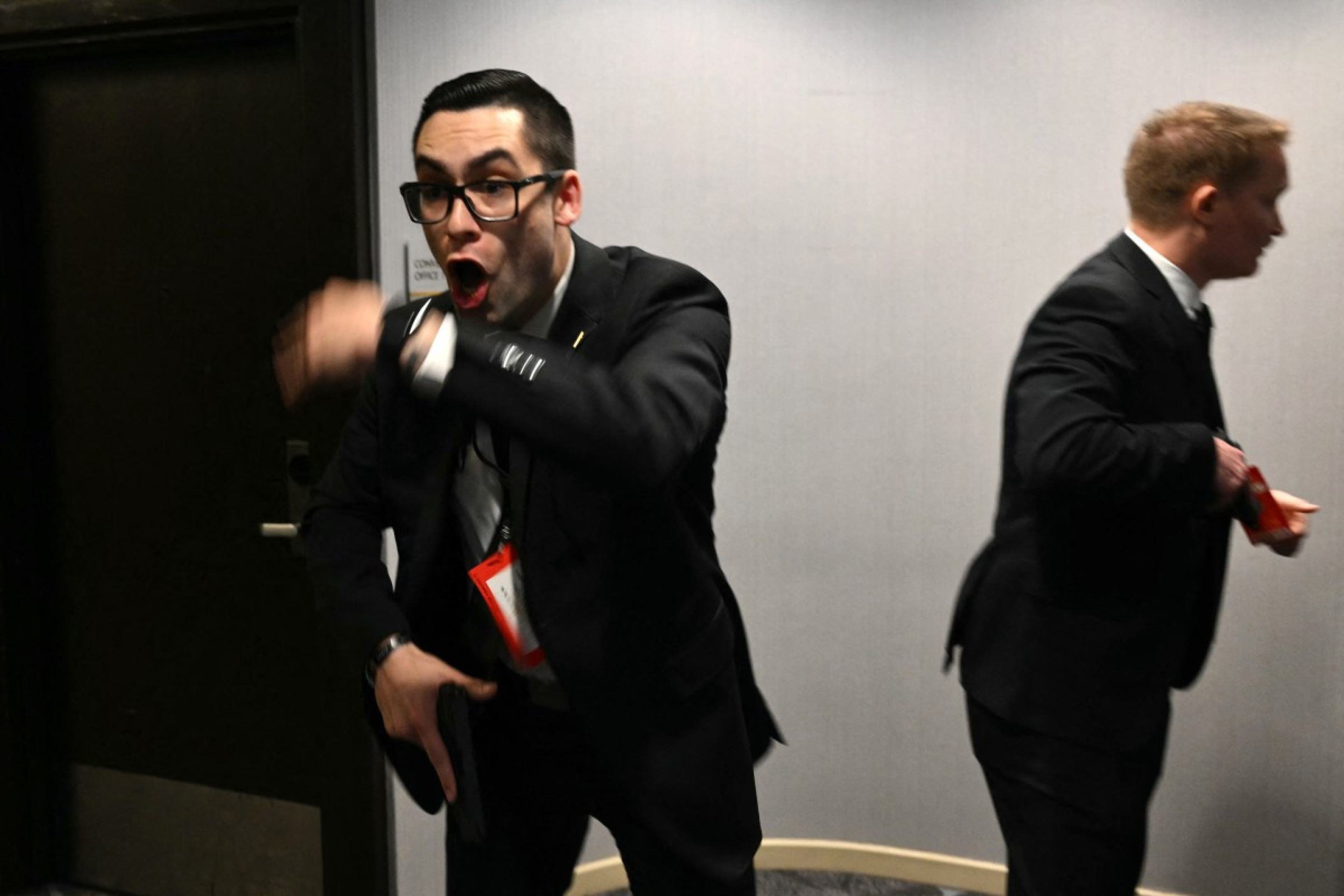  Agents draw their guns after loud bangs were heard during the White House Correspondents' dinner at the Washington Hilton in Washington, DC, on April 25, 2026. President Trump is attending the annual gala of the political press for the first time while in office. (Photo by Mandel NGAN / AFP)
      Caption 