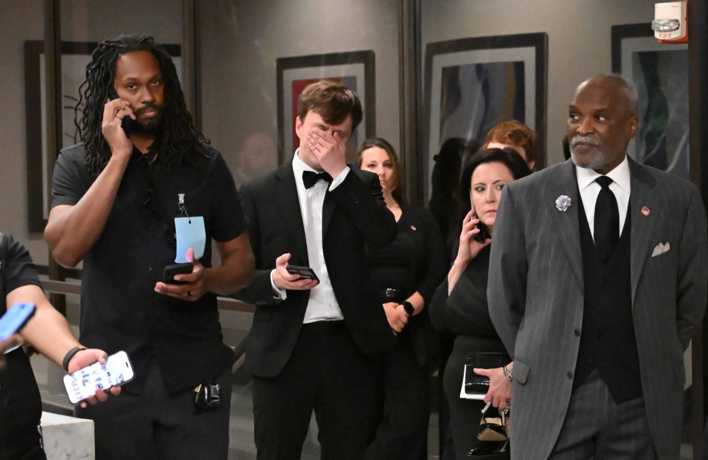  Attendees check their phones in the lobby of the Washington Hilton after shots were heard during the White House Correspondents' Dinner in Washington, DC, on April 25, 2026. Shots were fired as US President Donald Trump attended a press dinner in Washington on April 25 night, witnesses and AFP reporters confirmed. Loud bangs were heard and guests at the black-tie White House Correspondents' Dinner scrambled to hide under tables. Tactical teams with guns drawn took position on the stage where Trump had been sitting before he was evacuated. (Photo by Alex WROBLEWSKI / AFP)
      