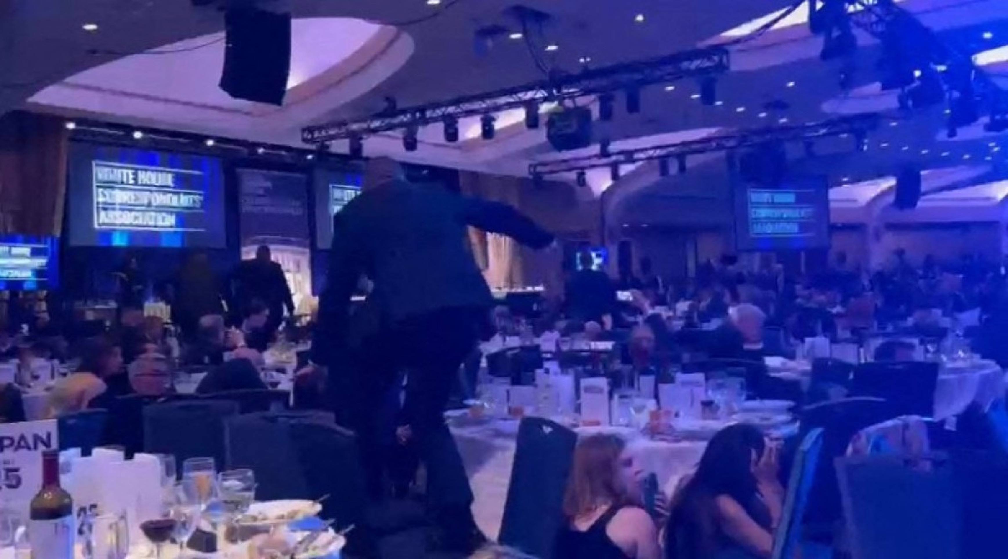  A screen grab taken from a video filmed by an AFP reporter shows armed agents climbing over chairs as they move to the stage after loud bangs were heard during the White House Correspondents' dinner at the Washington Hilton in Washington, DC, on April 25, 2026. Shots were fired as US President Donald Trump attended a press dinner in Washington on Saturday night, witnesses and AFP reporters confirmed. Loud bangs were heard and guests at the black-tie White House Correspondents' Dinner scrambled to hide under tables. (Photo by Danny KEMP and AFPTV teams / AFP)
      