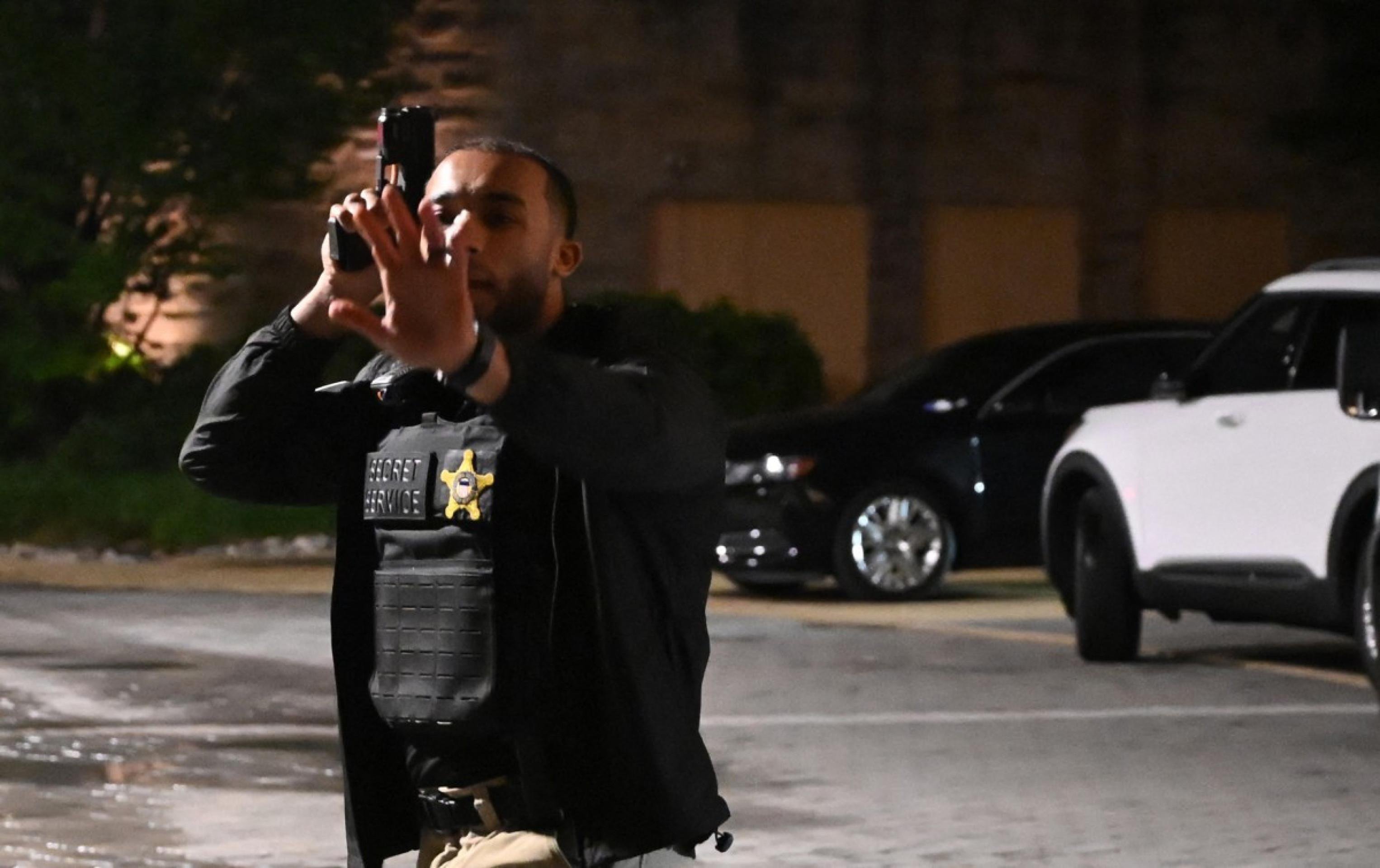  A Secret Service officer directs people outside the Washington Hilton after shots were heard during the White House Correspondents' Dinner in Washington, DC, on April 25, 2026. President Trump is attending the annual gala of the political press for the first time while in office. (Photo by Alex WROBLEWSKI / AFP)
      