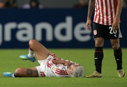 A dor de Arrascaeta ao fraturar a clav&iacute;cula durante o empate por 1 x 1 com o Estudiantes       -  (crédito: Juan Mabromata/AFP) -A dor de Arrascaeta ao fraturar a clav&iacute;cula durante o empate por 1 x 1 com o Estudiantes       -  (crédito: Juan Mabromata/AFP)
