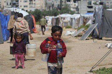 Crianças buscam água potável no campo de refugiados de Bureij, no centro da Faixa de Gaza, em 28 de abril de 2026. A maioria dos 2,4 milhões de habitantes de Gaza foi deslocada, muitas vezes repetidamente, pela guerra que começou com o ataque do Hamas ao sul de Israel em 7 de outubro de 2023. Com famílias deslocadas vivendo em acampamentos de tendas, pairam sérias preocupações sobre suas condições de vida. (Foto de Eyad Baba / AFP) -  (crédito:  AFP)