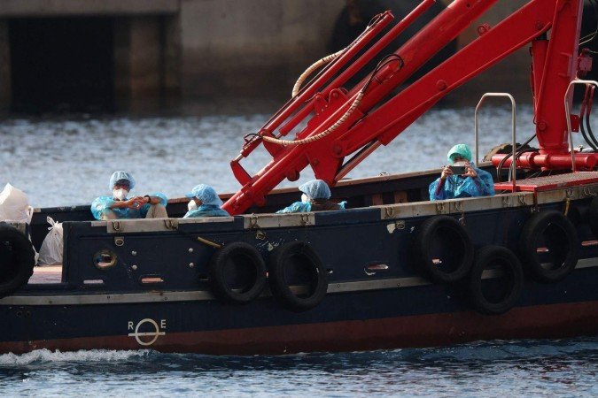 Passageiros do navio de cruzeiro MV Hondius aguardam na pista do aeroporto de Tenerife Sul, em Tenerife - (crédito: BBC) Passageiros do navio de cruzeiro MV Hondius aguardam na pista do aeroporto de Tenerife Sul, em Tenerife - (crédito: BBC)