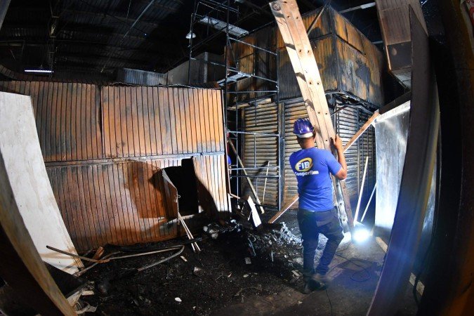 Homens trabalham na reforma do espaço atingido pelo fogo na Feira dos Importados