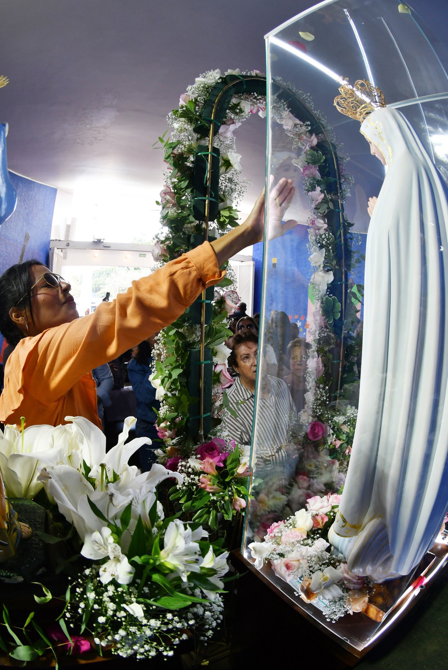 Devota toca na imagem durante missa