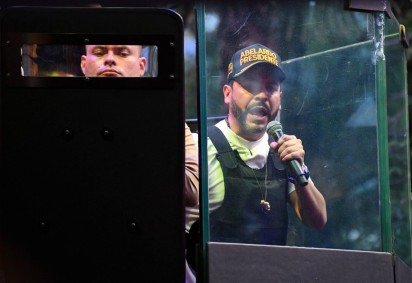 O candidato presidencial de direita da Colômbia, Abelardo de la Espriella, do movimento Defensores de la Patria, discursa atrás de um vidro blindado durante um comício de campanha em Envigado, departamento de Antioquia, Colômbia, em 13 de maio de 2026 -  (crédito: Jaime SALDARRIAGA / AFP) -O candidato presidencial de direita da Colômbia, Abelardo de la Espriella, do movimento Defensores de la Patria, discursa atrás de um vidro blindado durante um comício de campanha em Envigado, departamento de Antioquia, Colômbia, em 13 de maio de 2026 -  (crédito: Jaime SALDARRIAGA / AFP)