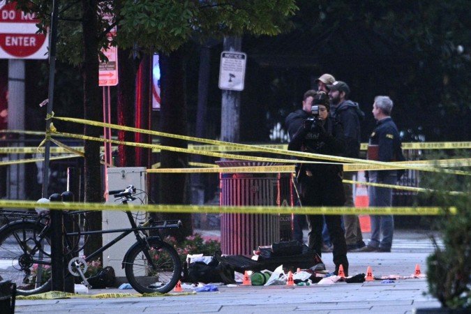  A forensic investigator takes photos behind a police tape blocking off a crime scene with evidence markers seen on a sidewalk on 17th and Pennsylvania Ave near the White House in Washington, DC, on May 23, 2026. Police and security forces swarmed the area around the White House on the evening of May 23 after reports of shots fired, AFP journalists said. US President Donald Trump was at the White House at the time as he worked to negotiate a deal with Iran. (Photo by Brendan SMIALOWSKI / AFP)
      