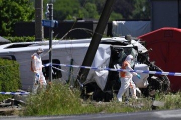 Agentes da Polícia Forense inspecionam o ônibus danificado no local do acidente, após um trem colidir com um ônibus escolar, na passagem de nível de Vierhuizen, em Buggenhout, a cerca de 20 km ao norte de Bruxelas, em 26 de maio de 2026. - (crédito: AFP) Agentes da Polícia Forense inspecionam o ônibus danificado no local do acidente, após um trem colidir com um ônibus escolar, na passagem de nível de Vierhuizen, em Buggenhout, a cerca de 20 km ao norte de Bruxelas, em 26 de maio de 2026. - (crédito: AFP)