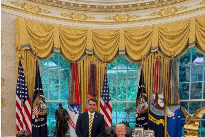  O senador Fl&aacute;vio Bolsonaro ao lado do presidente Donald Trump na Casa Branca, em 26 de maio de 2026 .