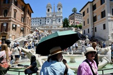 Na Praça da Espanha, em Roma, turistas tentam se proteger do calor de 32°C registrado ontem: clima é incomum para maio, e governo italiano decretou alerta vermelho
 -  (crédito: AFP)