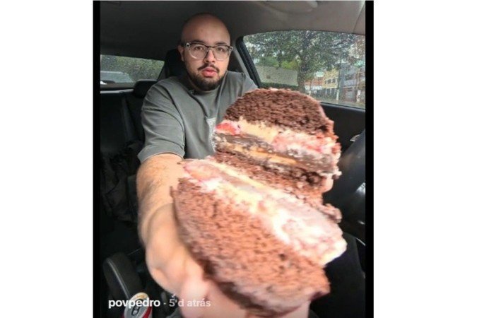 Homem exibe o X-bolo, a sobremesa que imita um hambúrguer e viraliza no TikTok, dentro de um carro. - (crédito: Reprodução/TikTok) Homem exibe o X-bolo, a sobremesa que imita um hambúrguer e viraliza no TikTok, dentro de um carro. - (crédito: Reprodução/TikTok)