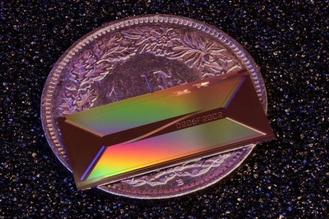 Colocado sobre uma moeda de 1 franco suíço para comparação de tamanho, o chip fotônico da EPFL demonstra como uma arquitetura a laser, antes restrita a sistemas de mesa, pode ser reduzida à escala milimétrica - (crédito: Reprodução / Zheru Qiu/EPFL) Colocado sobre uma moeda de 1 franco suíço para comparação de tamanho, o chip fotônico da EPFL demonstra como uma arquitetura a laser, antes restrita a sistemas de mesa, pode ser reduzida à escala milimétrica - (crédito: Reprodução / Zheru Qiu/EPFL)
