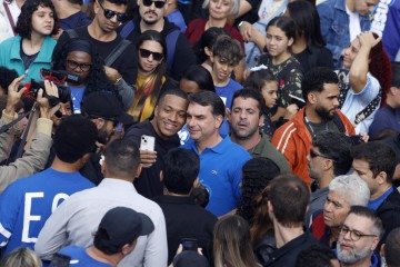 O senador e candidato à presidência Flávio Bolsonaro (C) posa para uma selfie com apoiadores durante a 'Marcha por Jesus', evento que reúne diversas congregações evangélicas, em São Paulo, Brasil, em 4 de junho de 2026       -  (crédito: MIGUEL SCHINCARIOL / AFP)