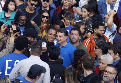 O senador e candidato à presidência Flávio Bolsonaro (C) posa para uma selfie com apoiadores durante a 