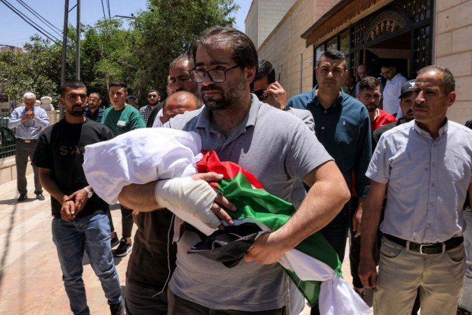 O palestino Fahd Abou Haikal carrega o corpo de seu filho de sete meses, Sam, durante o funeral em Hebron, na Cisjordânia ocupada, em 6 de junho de 2026 - (crédito: HAZEM BADER / AFP) O palestino Fahd Abou Haikal carrega o corpo de seu filho de sete meses, Sam, durante o funeral em Hebron, na Cisjordânia ocupada, em 6 de junho de 2026 - (crédito: HAZEM BADER / AFP)