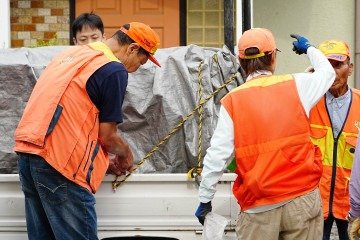 Homens posam ao lado de um caminhão que transporta um urso selvagem sedado após sua captura em Utsunomiya, ao norte de Tóquio, em 9 de junho de 2026       -  (crédito: YUICHI YAMAZAKI / AFP)