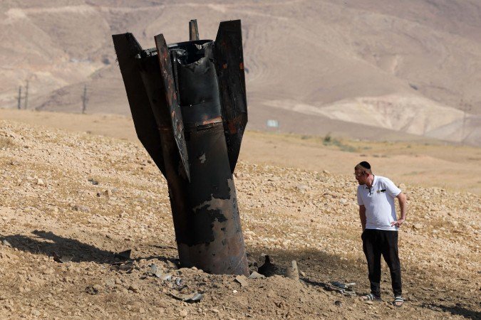Morador de Jericó, em Israel, observa míssil iraniano parcialmente enterrado depois de cair perto da cidade