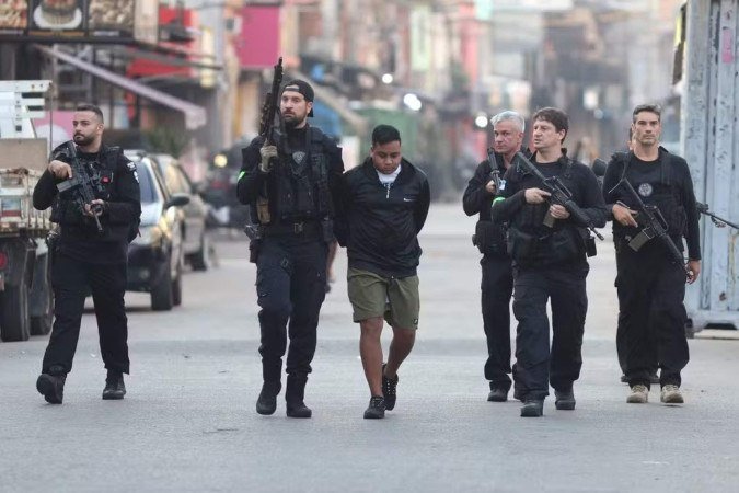 Policiais civis conduzem um preso em operação no Complexo da Maré - (crédito: Fabiano Rocha / Agência O Globo) Policiais civis conduzem um preso em operação no Complexo da Maré - (crédito: Fabiano Rocha / Agência O Globo)