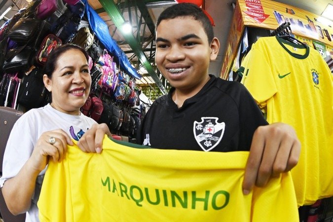 Rita de Cássia e o filho Marquinho personalizaram a camisa para entrar com o pé direito na estreia da Seleção - (crédito: Ed Alves/CB/D.A Press) Rita de Cássia e o filho Marquinho personalizaram a camisa para entrar com o pé direito na estreia da Seleção - (crédito: Ed Alves/CB/D.A Press)