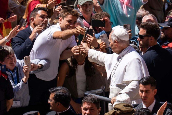 Momento em que Leão XIV recebe rosário de jovem.