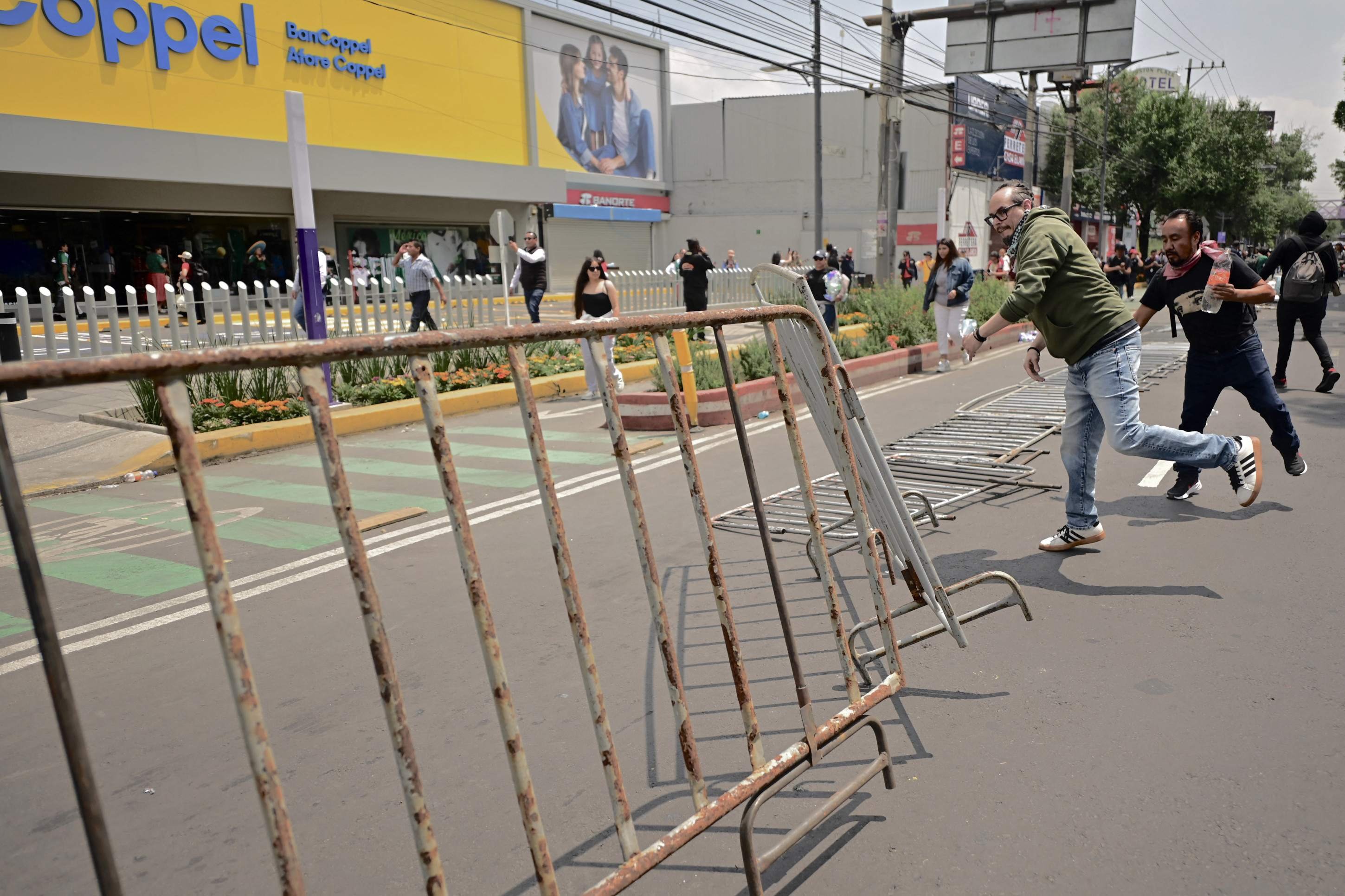  Protesters turn down fences as they march towards the Mexico City Stadium ahead of the opening ceremony of the FIFA 2026 World Cup in Mexico City on June 11, 2026. (Photo by Marco Antonio MARTINEZ / AFP)       