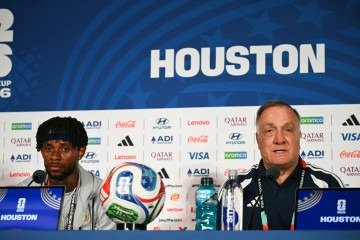 O técnico holandês de Curaçao, Dick Advocaat (à direita), concede uma entrevista coletiva ao lado do meio-campista de Curaçao, camisa 10, Leandro Bacuna, na véspera da partida de futebol do Grupo E da Copa do Mundo de 2026 contra a Alemanha, em Houston, em 13 de junho de 2026       -  (crédito: RONALDO SCHEMIDT / AFP)