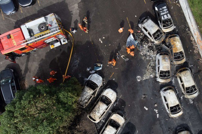 Uma vista aérea mostra bombeiros trabalhando no local da queda de um helicóptero no bairro do Recreio dos Bandeirantes, no Rio de Janeiro, Brasil, em 14 de junho de 2026     