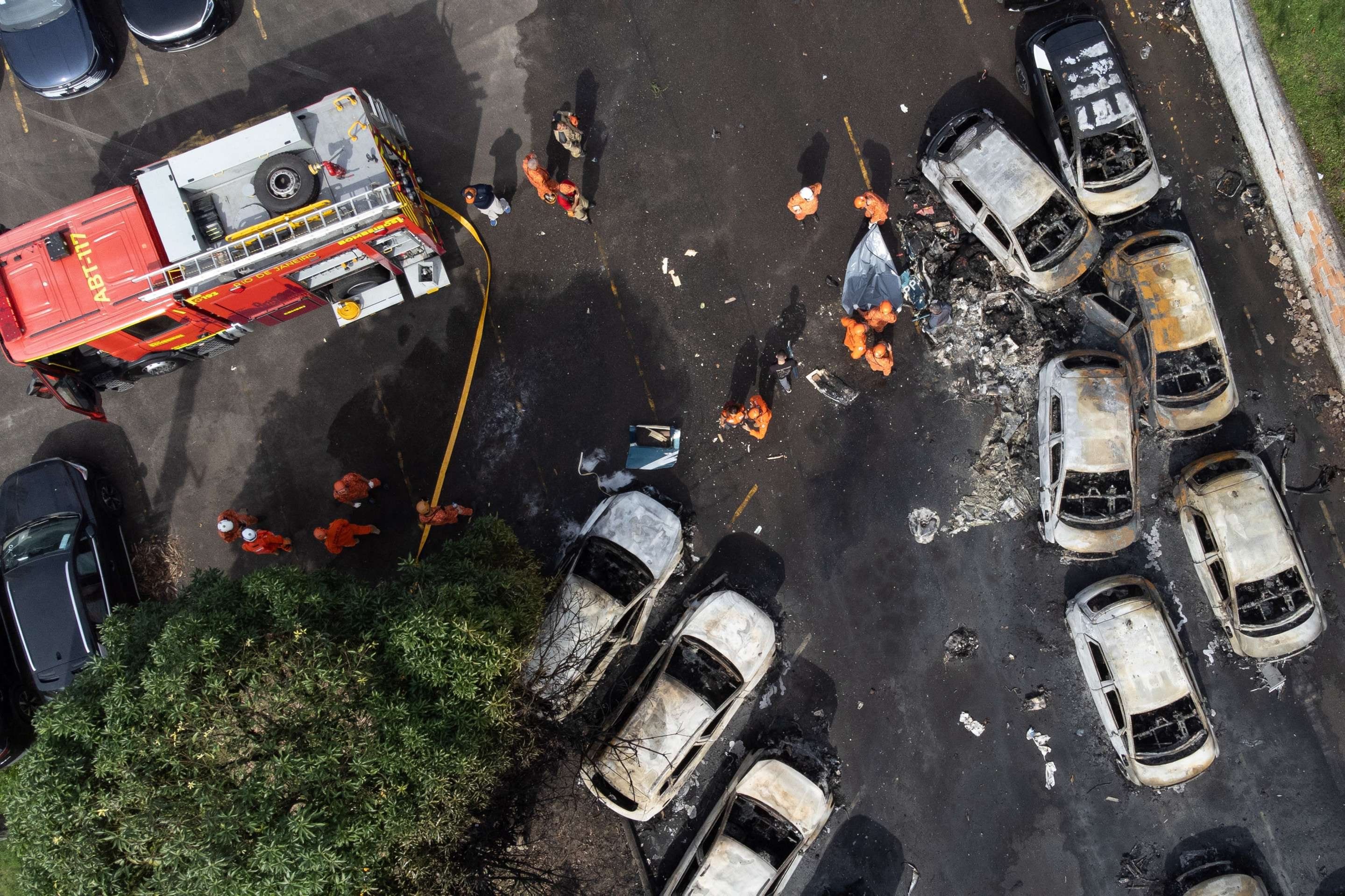 Uma vista aérea mostra bombeiros trabalhando no local da queda de um helicóptero no bairro do Recreio dos Bandeirantes, no Rio de Janeiro, Brasil, em 14 de junho de 2026     