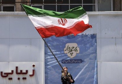 Iraniana faz tremular a bandeira do país na Praça Valiasr, em Teerã: regime declarou vitória na guerra -  (crédito: Atta Kenare/AFP) -Iraniana faz tremular a bandeira do país na Praça Valiasr, em Teerã: regime declarou vitória na guerra -  (crédito: Atta Kenare/AFP)