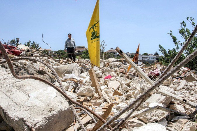 Bandeira do Hezbollah sobre escombros no sul do Líbano