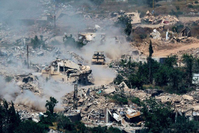 Tanques Merkava, das Forças de Defesa de Israel, deslocam-se por estrada no sul do Líbano, em meio a prédios destruídos - (crédito: Jack Guez/AFP) Tanques Merkava, das Forças de Defesa de Israel, deslocam-se por estrada no sul do Líbano, em meio a prédios destruídos - (crédito: Jack Guez/AFP)
