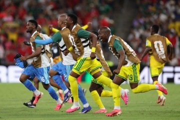 Sul-africanos comemoram a vitória que garantiu a classificação histórica à fase de mata-mata       -  (crédito: Julio Cesar AGUILAR / AFP)