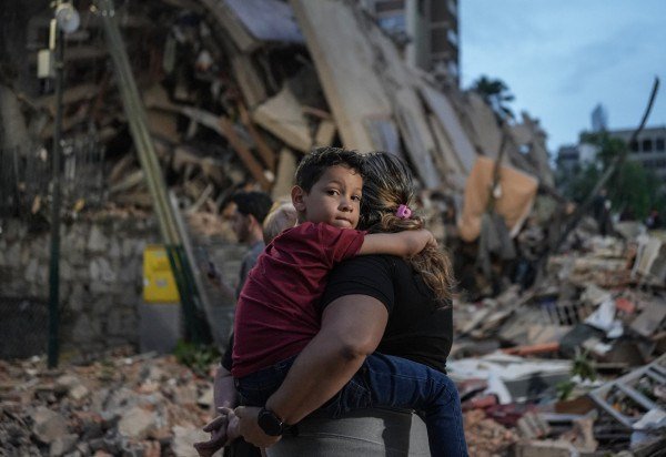 Pessoas passam por um prédio que desabou após um terremoto em Caracas, em 25 de junho de 2026. -  (crédito:  AFP)