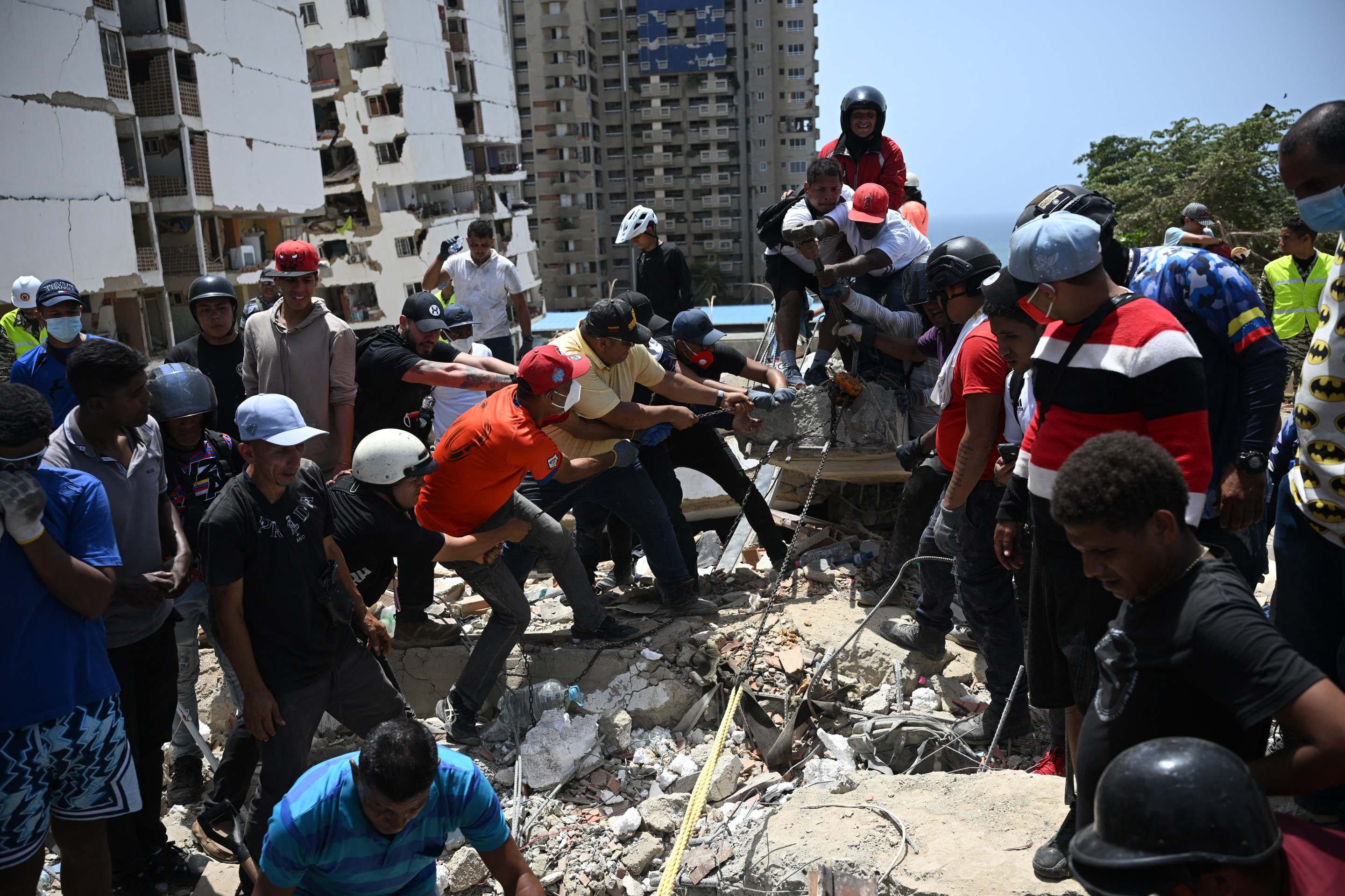 Volunt&aacute;rios usam corda para tentar recuperar corpo sob a pilha de concretos, em Catia La Mar, tamb&eacute;m em La Guaira