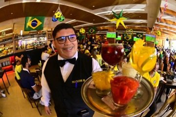 Marcos Henrique de Oliveira encontrou brechas entre um atendimento e outro para assistir a alguns lances da partida -  (crédito: ED ALVES/CB/D.A.Press)