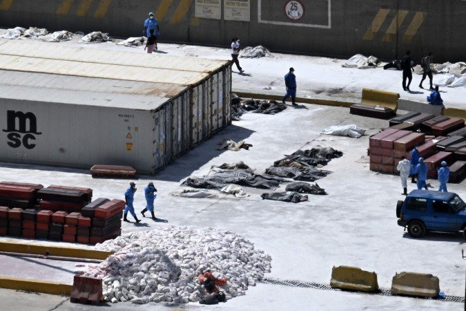 Médicos legistas próximo aos corpos das vítimas, no porto de La Guairda: autoridades usam cal para tentar desacelerar a decomposição - (crédito: Juan Barreto/AFP) Médicos legistas próximo aos corpos das vítimas, no porto de La Guairda: autoridades usam cal para tentar desacelerar a decomposição - (crédito: Juan Barreto/AFP)