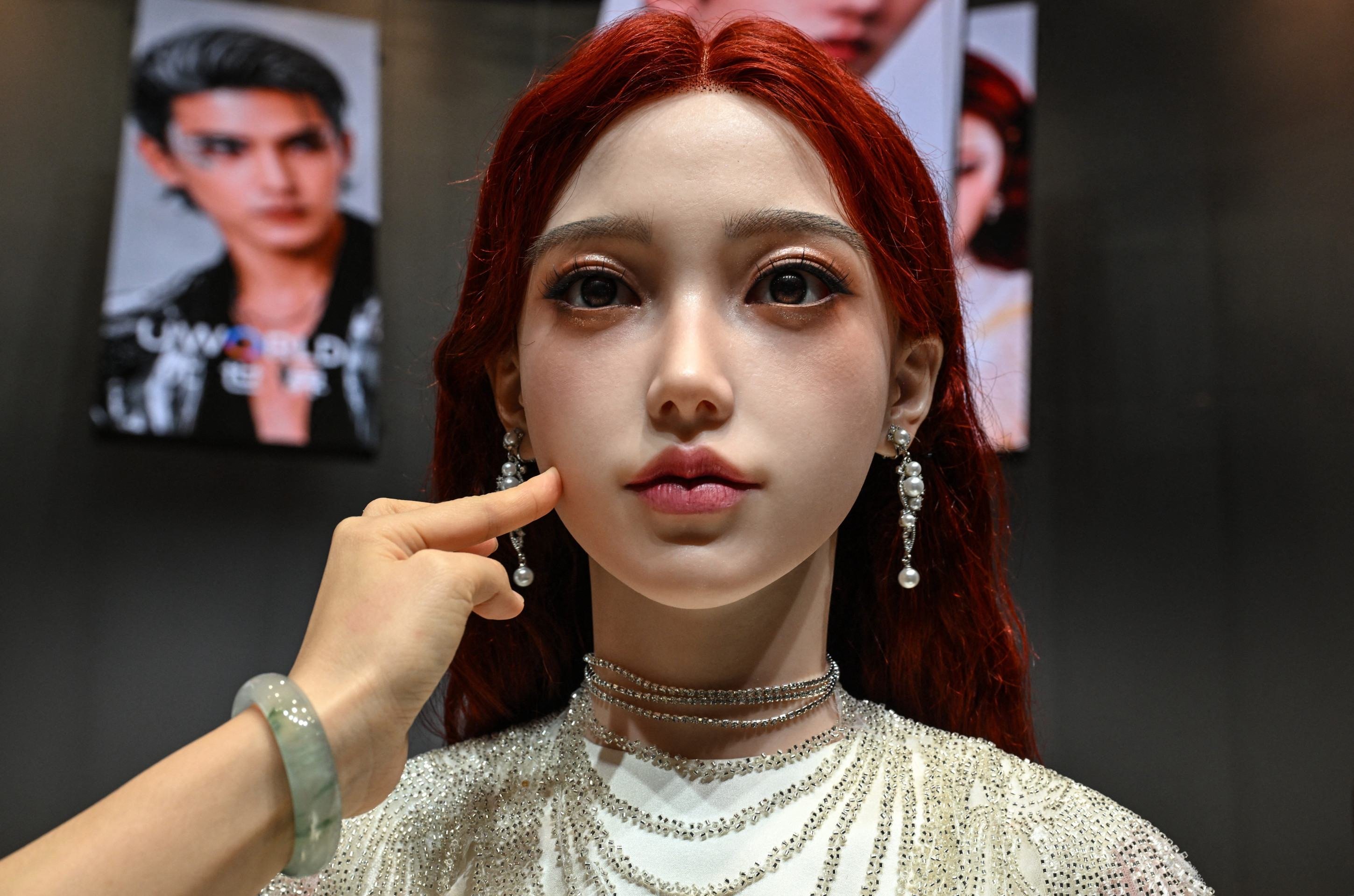  A woman touches the face of a humanoid robot during the launch of the U1 humanoid robot produced by UWORLD, a brand under UBTECH Robotics, in Shenzhen, Chinas Guangdong province on June 30, 2026. Silicone skin, soothing voice: Chinese company UBTech unveiled unprecedented hyper-realistic human-looking androids equipped with artificial intelligence (AI) and presented as anti-loneliness remedies. (Photo by ADEK BERRY / AFP)       