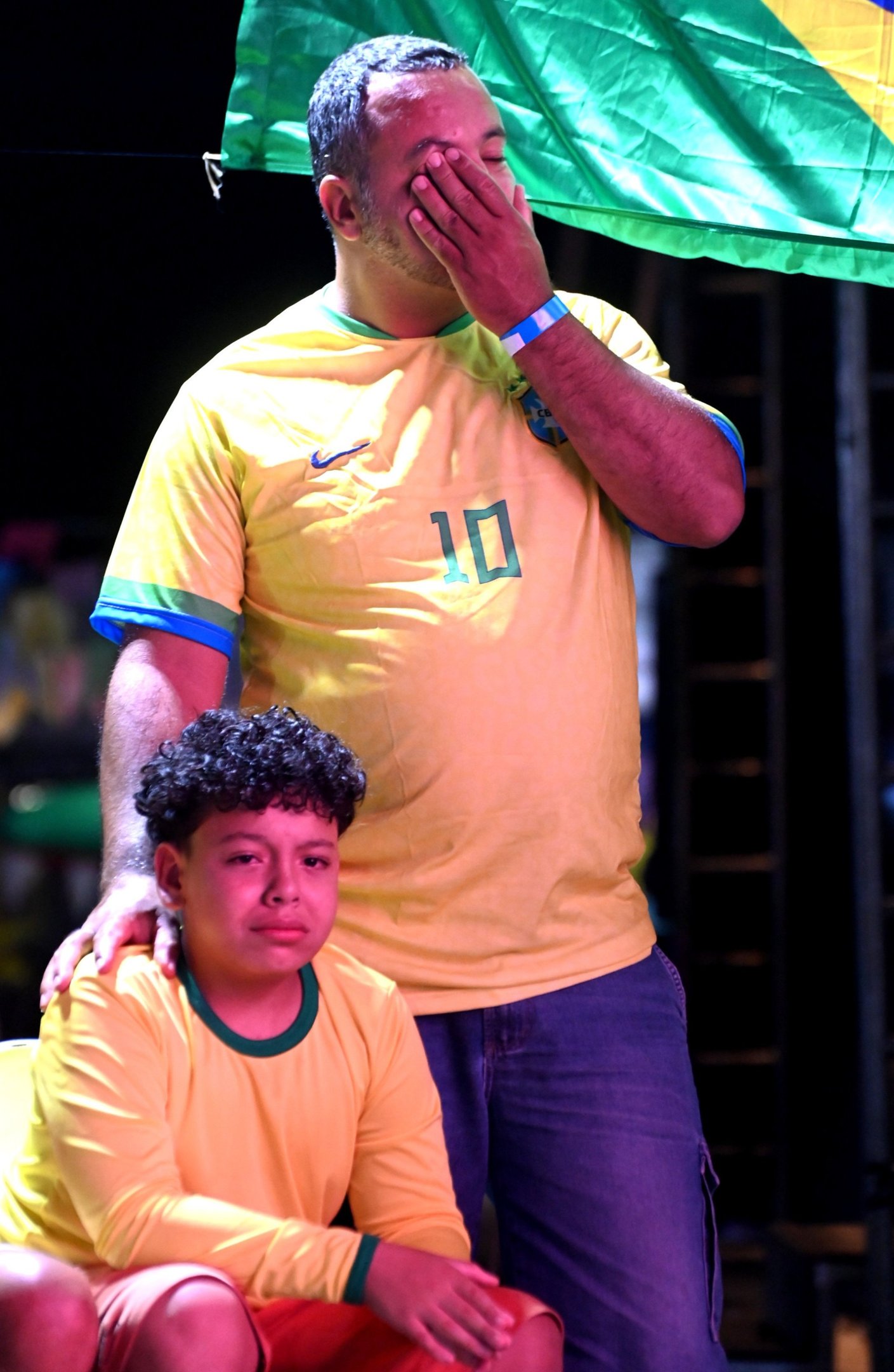 O pequeno Miguel Bonfim, 11 anos, &eacute; consolado pelo pai Leoni: 