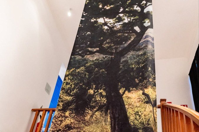 Terra que Guarda, instalação de oito metros de altura que ocupa a escadaria principal do museu com a imagem de uma árvore e suas raízes bordadas