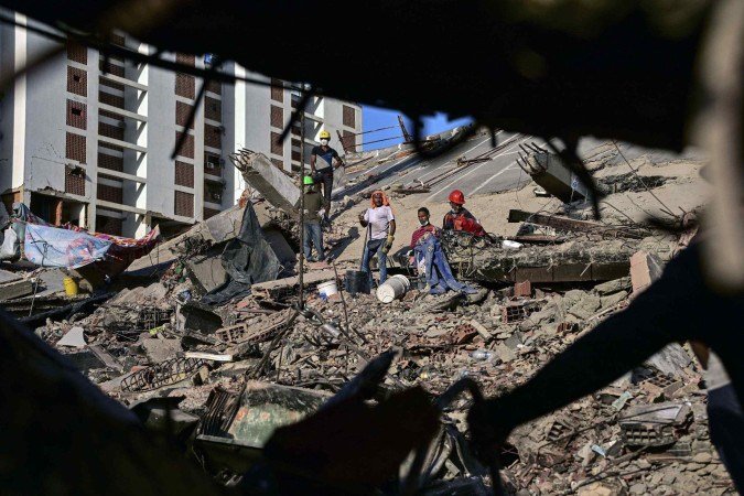 Rescuers rest on the rubble of a collapsed building in Caraballeda, La Guaira state, Venezuela, on July 7, 2026, following the June 24 earthquakes. The powerful twin earthquakes that struck Venezuela on June 24 have left at least 3,685 dead and nearly 17,000 injured, the Venezuelan government said in its latest official update on July 7. (Photo by MARTIN BERNETTI / AFP)
- (crédito: AFP) Rescuers rest on the rubble of a collapsed building in Caraballeda, La Guaira state, Venezuela, on July 7, 2026, following the June 24 earthquakes. The powerful twin earthquakes that struck Venezuela on June 24 have left at least 3,685 dead and nearly 17,000 injured, the Venezuelan government said in its latest official update on July 7. (Photo by MARTIN BERNETTI / AFP)
- (crédito: AFP)
