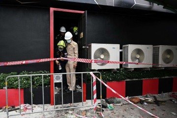Policiais e equipes de resgate examinam o local após um incêndio no bar Rong Beer Na Lat Phrao, em Bangkok, em 13 de julho de 2026 - (crédito: LILLIAN SUWANRUMPHA / AFP) Policiais e equipes de resgate examinam o local após um incêndio no bar Rong Beer Na Lat Phrao, em Bangkok, em 13 de julho de 2026 - (crédito: LILLIAN SUWANRUMPHA / AFP)