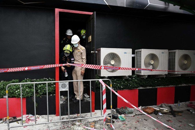 Policiais e equipes de resgate examinam o local após um incêndio no bar Rong Beer Na Lat Phrao, em Bangkok, em 13 de julho de 2026 - (crédito: LILLIAN SUWANRUMPHA / AFP) Policiais e equipes de resgate examinam o local após um incêndio no bar Rong Beer Na Lat Phrao, em Bangkok, em 13 de julho de 2026 - (crédito: LILLIAN SUWANRUMPHA / AFP)