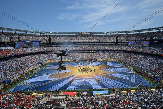 Uma visão geral mostra espectadores observando dançarinos e músicos se apresentarem durante a cerimônia de encerramento da final da Copa do Mundo de 2026 - (crédito: ANGELA WEISS / AFP) Uma visão geral mostra espectadores observando dançarinos e músicos se apresentarem durante a cerimônia de encerramento da final da Copa do Mundo de 2026 - (crédito: ANGELA WEISS / AFP)