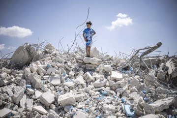 Garoto palestino sobre escombros de lojas e apartamentos, ao sul de Jenin -  (crédito: John Wessels/AFP)