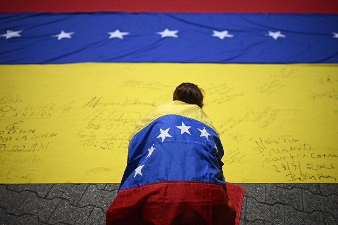 Sindicalista envolto na bandeira da Venezuela assina outra bandeira, durante protesto pelas eleições, na última terça-feira, em Caracas - (crédito: Federico Parra/AFP) Sindicalista envolto na bandeira da Venezuela assina outra bandeira, durante protesto pelas eleições, na última terça-feira, em Caracas - (crédito: Federico Parra/AFP)