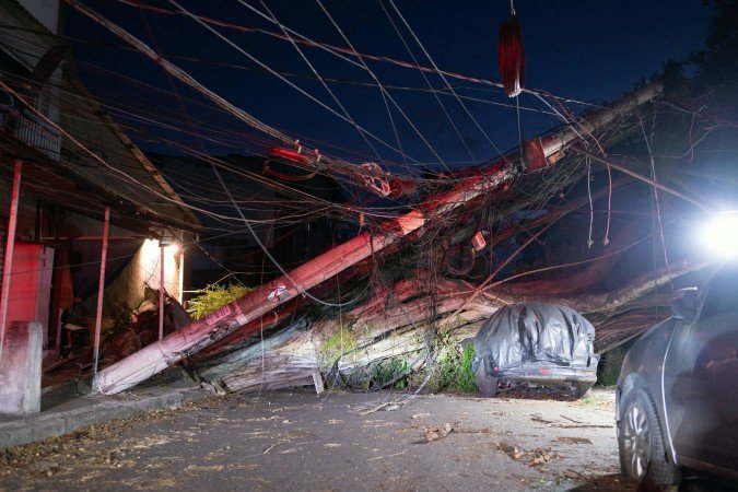 Postes de energia elétrica caíram, deixando vários bairros do Rio de Janeiro no escuro. Duas pessoas morream no bairro de Santa Teresa - (crédito: AFP) Postes de energia elétrica caíram, deixando vários bairros do Rio de Janeiro no escuro. Duas pessoas morream no bairro de Santa Teresa - (crédito: AFP)
