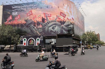 Motociclistas passam diante de outdoor com mensagem contra Washington, no centro de Teerã: Estátua da Liberdade no chão - (crédito: Atta Kenare/AFP) Motociclistas passam diante de outdoor com mensagem contra Washington, no centro de Teerã: Estátua da Liberdade no chão - (crédito: Atta Kenare/AFP)