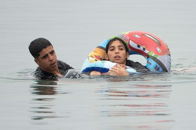 Com a ajuda de uma boia e amparada por outro marroquino, mulher nada para alcançar Ceuta 
      